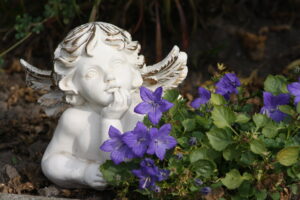 Eine Engelsfigur mit Blumen im Garten