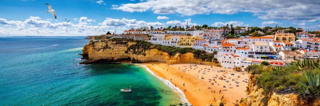Blick auf den Strand in der Stadt Carvoeiro mit bunten Häusern an der Küste von Portugal