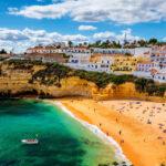 Blick auf den Strand in der Stadt Carvoeiro mit bunten Häusern an der Küste von Portugal