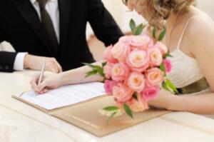 Braut unterschreibt Heiratsurkunde oder Hochzeitsvertrag