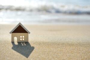 Kleines Modell Haus am Sandstrand in der Nähe des Meeres