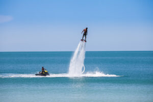 Mann fliegt mit Flyboard über dem Meer