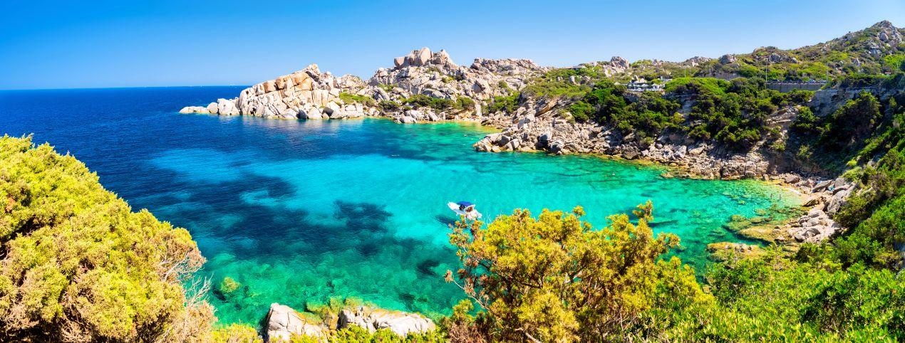 tuerkisfarbene Bucht mit Felsen und klarem Wasser an der suedlichen Kueste, ideal fuer ein Sardinien Ferienhaus am Meer