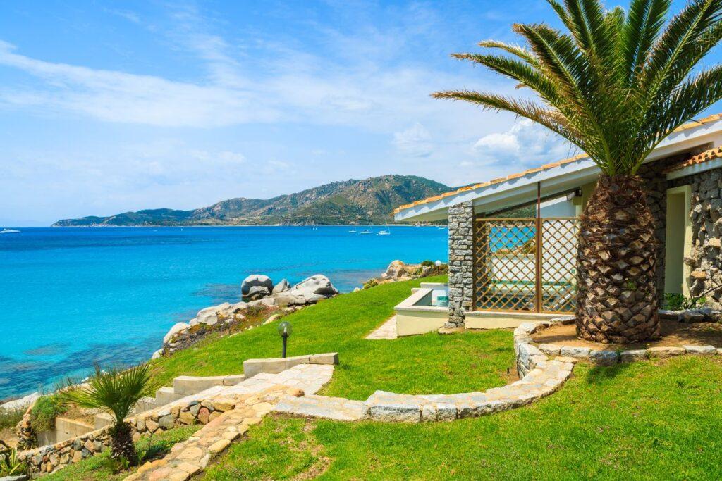 Ferienhaus mit Meerblick auf azurblaues Wasser und Felskueste, perfekt fuer ein Sardinien Ferienhaus am Meer